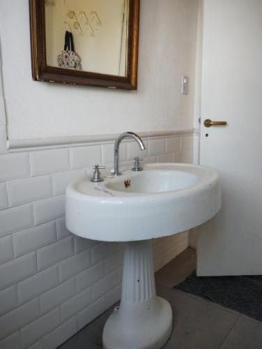 lavabo blanco en el baño con espejo en La pacaa` en Bella Vista