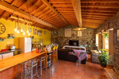 uma cozinha com paredes amarelas e tectos em madeira em Quinta Morazes Casas de Campo na Ribeira Grande