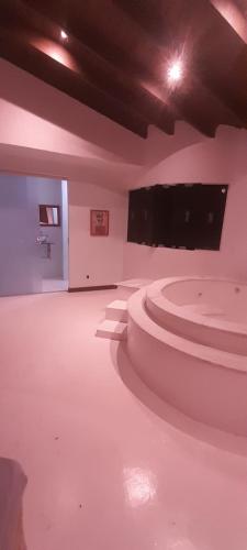 um quarto vazio com um piso branco e uma televisão em Casa 6 quartos piscina e sauna no Rio de Janeiro