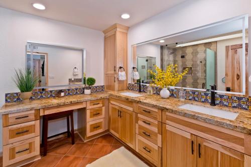 a bathroom with two sinks and a large mirror at Spectacular condo with private golf privileges includes golf cart on Monterey Country Club !! in Palm Desert