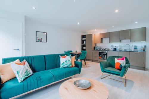 a living room with a blue couch and a table at Two Bedroom Urban Retreat in the Heart of Exeter in Exeter