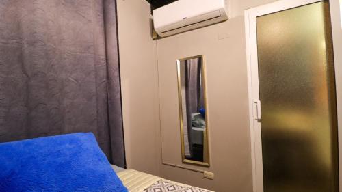 a bedroom with a blue bed and a mirror at Smart Inn in San Pedro Sula