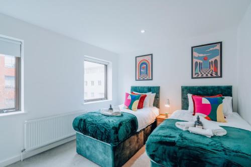 a bedroom with two beds and two windows at Two Bedroom Urban Retreat in the Heart of Exeter in Exeter