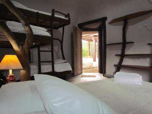 sypialnia z 2 łóżkami piętrowymi i drzwiami w obiekcie Boutique Hotel Casa de Guimarães w mieście Chapada dos Guimarães