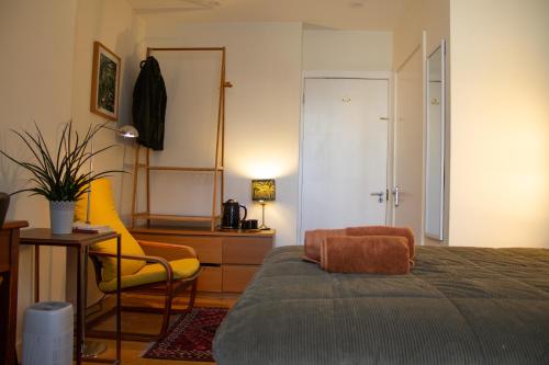 Cozy bedroom in Clapton home في لندن: غرفة نوم بسرير وكرسي وطاولة