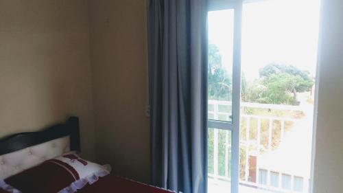 Un dormitorio con una cama y una ventana grande. en Chalé Sitio Miranda Sra Solange, en Aratuba