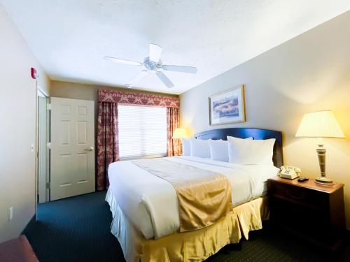 a bedroom with a large white bed with a ceiling fan at The Willowbrook Golf Hotel At Split Rock in Lake Harmony