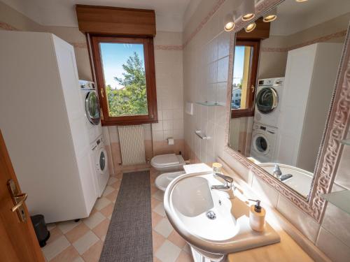 een badkamer met een wastafel, een toilet en een spiegel bij Bianco e Nero in Casale sul Sile
