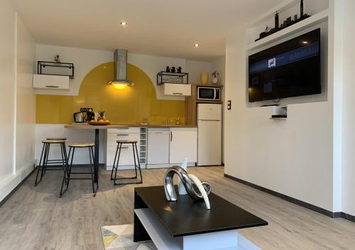 a living room with a large kitchen with a tv at L'Étoile de Mer - Étretat in Le Havre