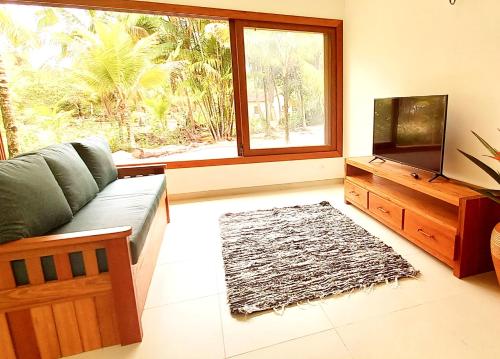 a living room with a couch and a television at Kíria's Village Beach House in Marau