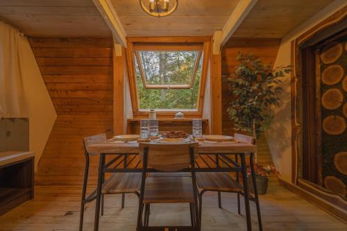 a table and chairs in a room with a window at Enchanting River- Water Front A-Frame Cabin in Yulan