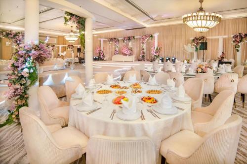 a banquet hall with a white table and chairs at Sheraton Abu Dhabi Hotel & Resort in Abu Dhabi