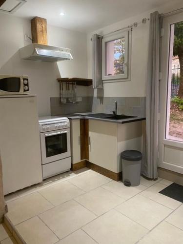 une cuisine avec un évier et une cuisinière dans l'établissement Jade, à Dompierre-sur-Charente