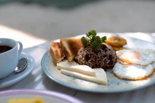 een bord eten met eieren en brood en een kop koffie bij Hotel Villabosque Eco Boutique in Manuel Antonio