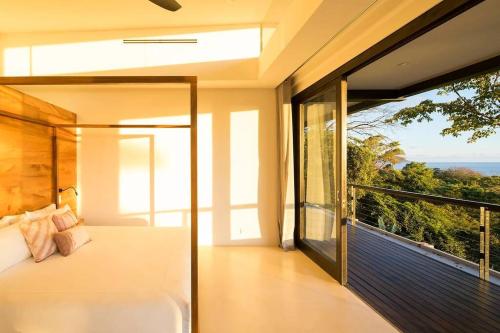 une chambre avec un lit et une grande fenêtre dans l'établissement Casa Maleku of Joya Luxury Estate, à Santa Teresa
