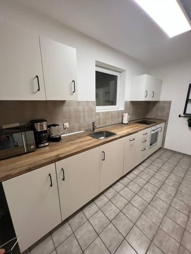 a kitchen with white cabinets and a sink at Sunset Apartment mit Rheinblick in Urbar in Urbar-Mayen-Koblenz