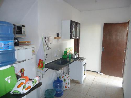 Una cocina con fregadero y refrigerador blanco. en Chalé Sitio Miranda Sra Solange, en Aratuba