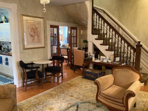 a living room with a staircase and chairs and a table at The Villa Toscana in Chicago