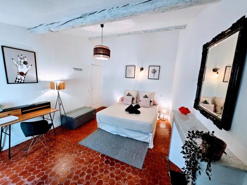 une chambre avec un lit sur lequel est assis un chat dans l'établissement 4 couchages Au Centre des Parfumeries, à Grasse