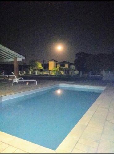 a large swimming pool at night with a street light at Linda casa em condomínio fechado para temporada. in Itatiba