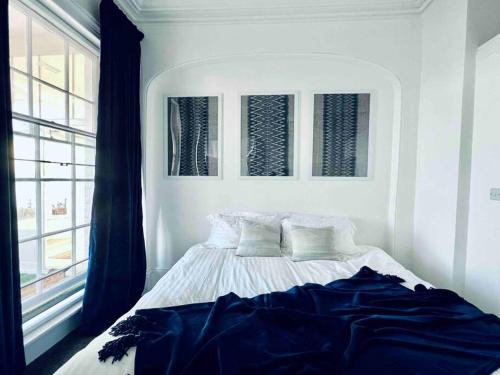 a white bedroom with a bed with pillows and a window at Flat 4 Marine Parade House, 1 East Cliff- Next to Dover Port, White Cliffs, Beach, Castle in Dover