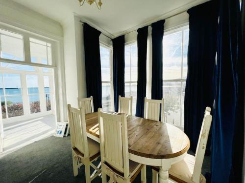 a dining room with a wooden table and chairs at Marine Parade House F4 Next to Dover Port, White Cliffs, Beach, Castle in Dover