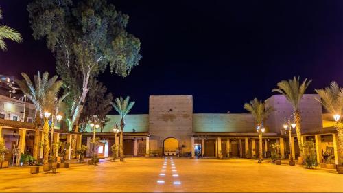 a building with palm trees and lights at night at Peace Hotel in Marrakesh