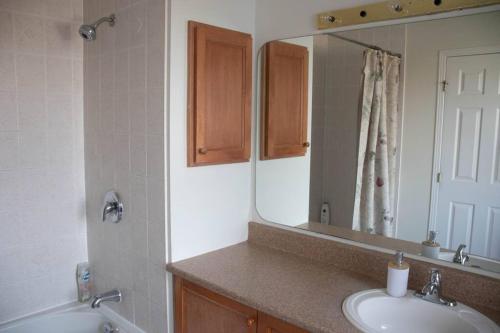 a bathroom with two sinks and a large mirror at Beautiful Home 5 Minutes from Ottawa Airport in Ottawa
