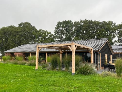 een houten paviljoen in het midden van een veld bij 't Heidepaleis in Garderen
