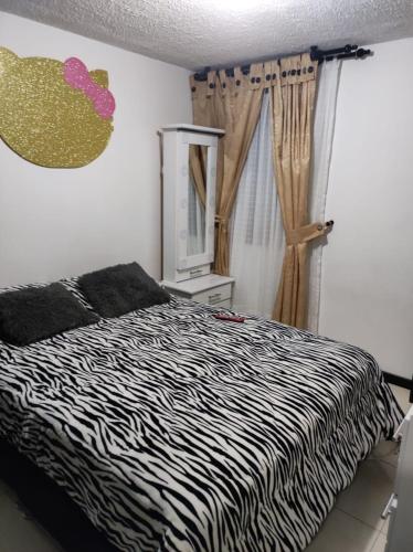 een slaapkamer met een bed met zebraprint en een raam bij APARTAMENTO CERCA A LA SENDA DEL CARNAVAL in Pasto