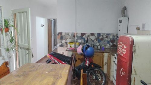 a kitchen with a table and a bike in a room at Tranquilidad en cosquin in Cordoba