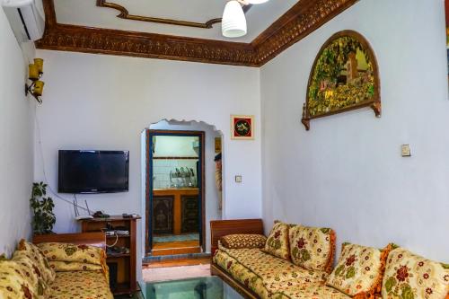 ein Wohnzimmer mit 2 Sofas und einem TV in der Unterkunft Lala Zohra in Chefchaouen