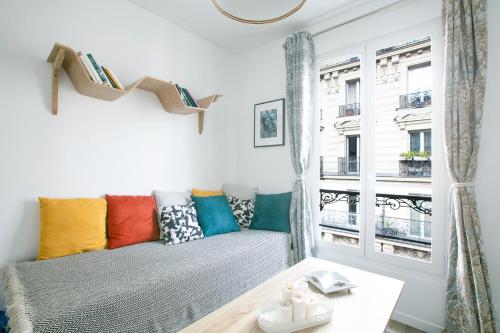 - un salon avec un canapé et des oreillers colorés dans l'établissement Charming 1 Bedroom Marais Hideaway - FB17A, à Paris