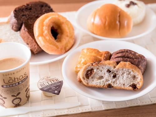 a tray with three plates of donuts and a cup of coffee at Super Hotel Yamagataeki Nishiguchi Hot Spring in Yamagata