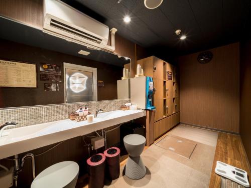 a kitchen with a sink and a refrigerator at Super Hotel Yamagataeki Nishiguchi Hot Spring in Yamagata