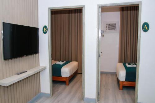 Cette chambre comprend une chambre avec un lit et une télévision. dans l'établissement Solano Residences, à Lipa