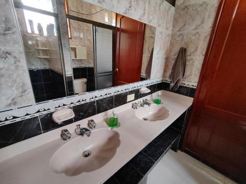 un bagno con due lavandini e un grande specchio di Bed&Breakfast - Mirador de San Marcos a Paipa