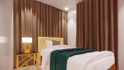 a bedroom with a bed and a chair and curtains at Solano Residences in Lipa
