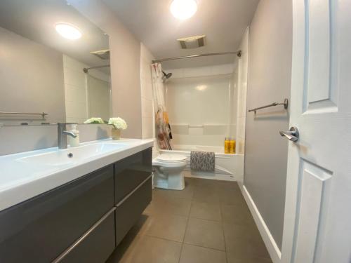 La salle de bains est pourvue d'un lavabo blanc et de toilettes. dans l'établissement lovely home, à Calgary