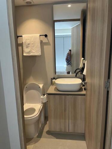 een badkamer met een toilet, een wastafel en een spiegel bij Apartamento en Bucerías frente al mar, condominio Tayau in Bucerías
