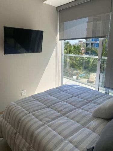 een slaapkamer met een bed en een groot raam bij Apartamento en Bucerías frente al mar, condominio Tayau in Bucerías