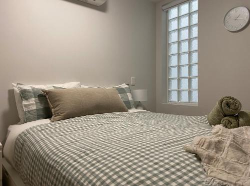 a bedroom with a bed with a clock on the wall at Tranquillity On The Promenade in Batemans Bay