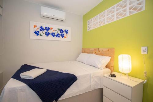 a small bedroom with a bed and a lamp at Studio na melhor quadra da Asa Norte in Brasilia
