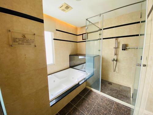 uma casa de banho com um chuveiro e uma banheira em Holland Hill Motel em Tainan