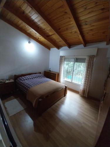 een slaapkamer met een bed en een groot raam bij La caprichosa mirador del Rio in Arroyo Seco