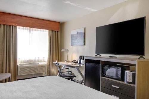 a hotel room with a bed and a flat screen tv at Best Western PLUS Peppertree Airport Inn in Spokane