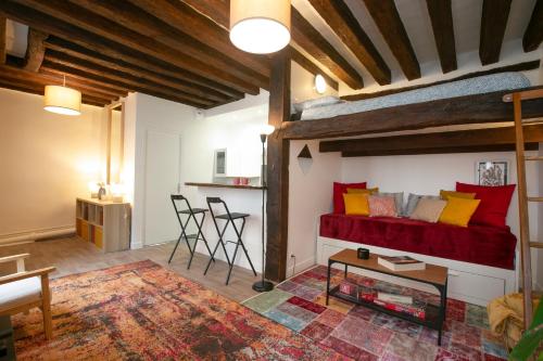 un salon avec un canapé rouge et une table dans l'établissement Authentic apartment in center of Parisian Marais, à Paris