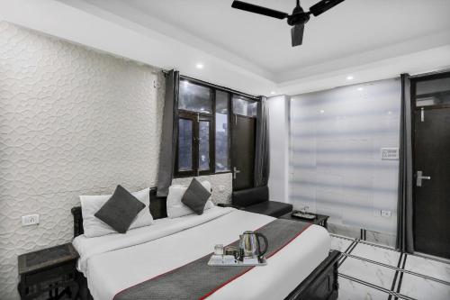 a bedroom with a large white bed and windows at Collection O AP Grand in Noida