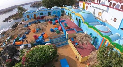 ein Kinderspielplatz am Strand mit Sonnenschirmen in der Unterkunft Adad Noubian House in Assuan