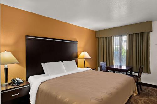 a hotel room with a large bed and a desk at Quality Inn Saint George South Bluff in St. George